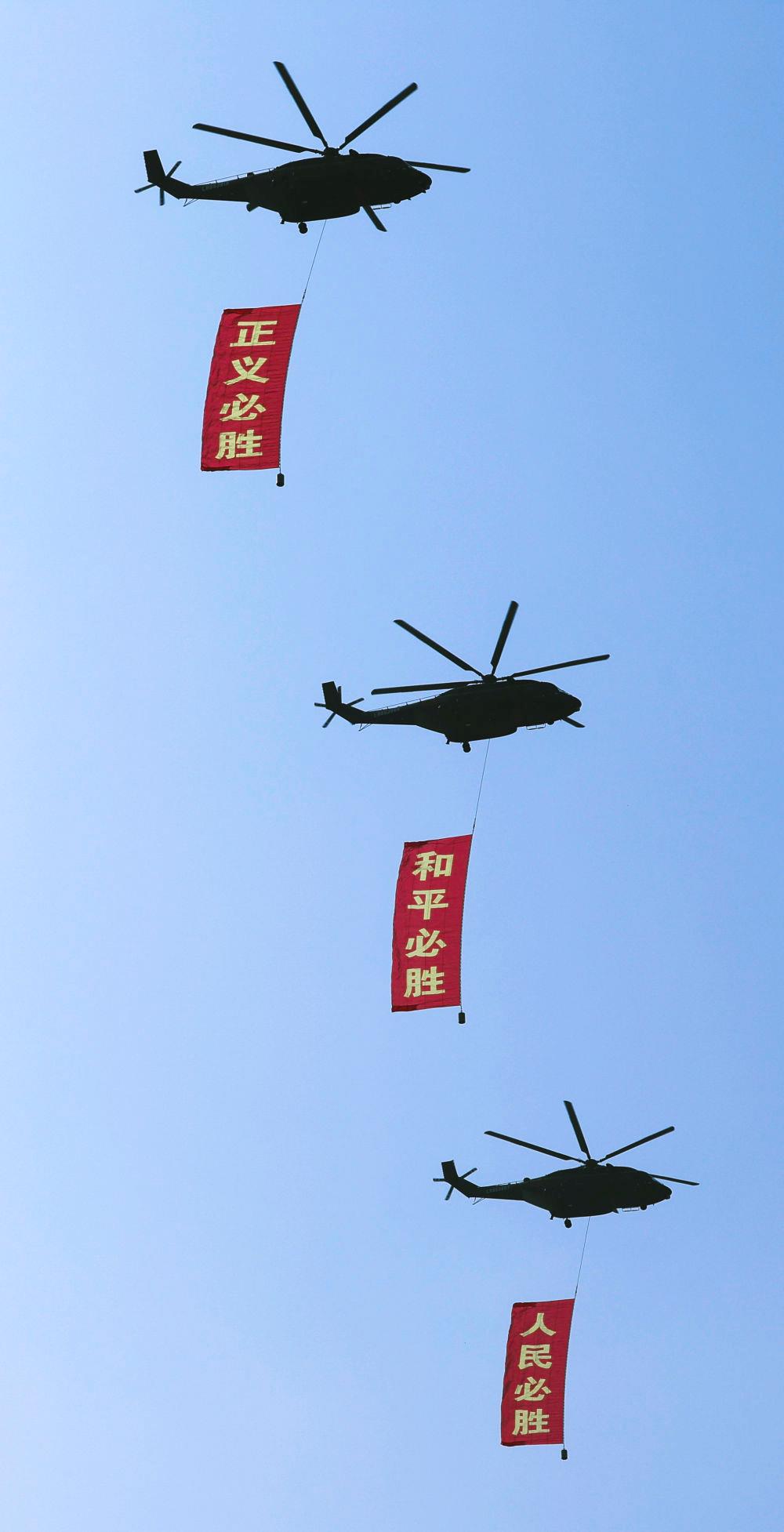 △2025年9月3日,纪念中国人民抗日战争暨世界反法西斯战争胜利80周年大会在北京隆重举行。这是空中护旗梯队通过天安门广场,3架直-8L运输直升机分别悬挂“正义必胜”“和平必胜”“人民必胜”条幅。
