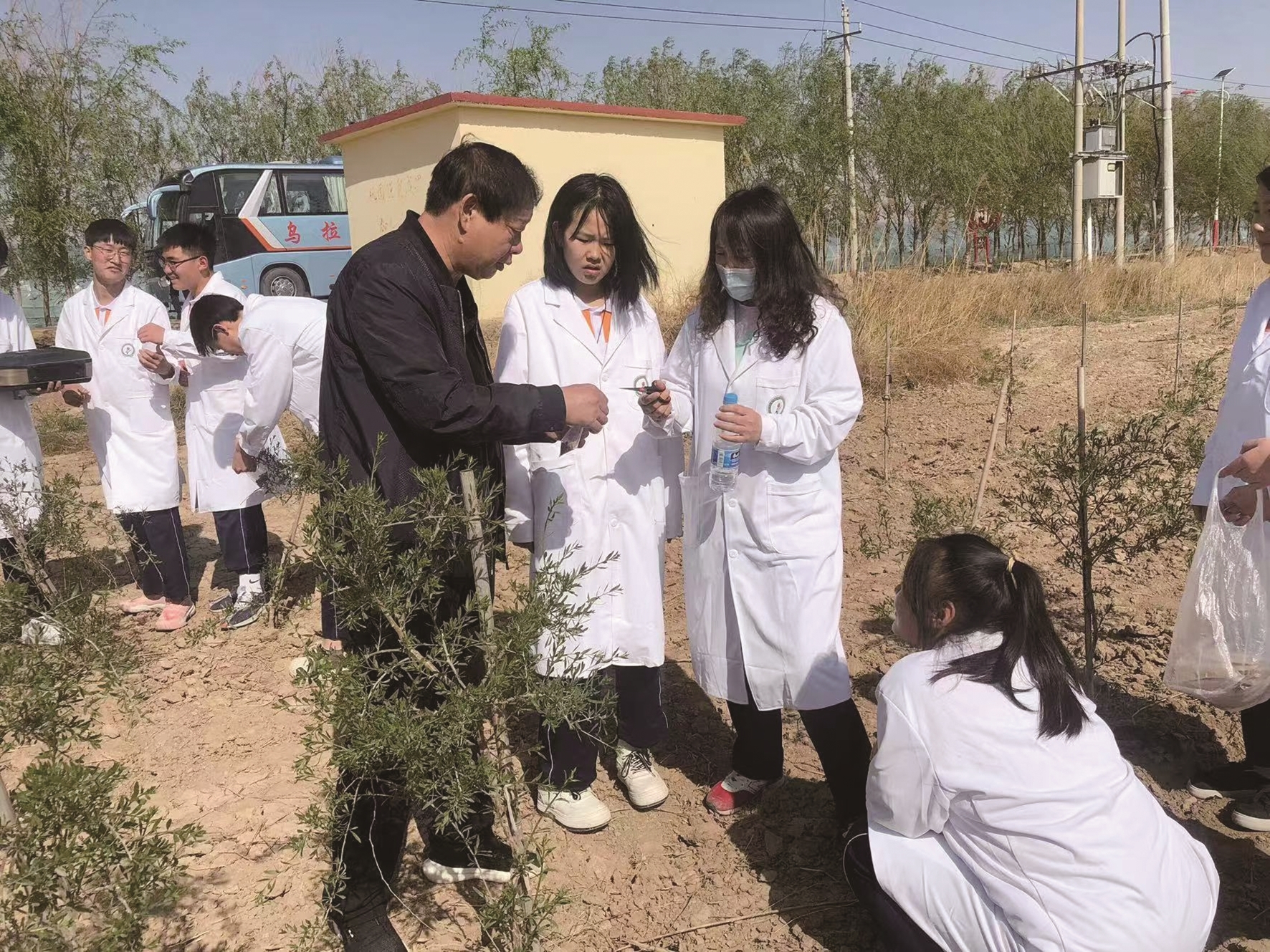 刘俊清(左一)指导团队成员在地里投放植绥螨