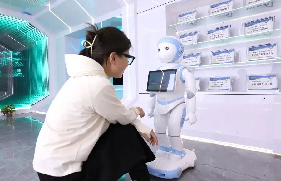 工作人员与一款人工智能机器人互动。 图片