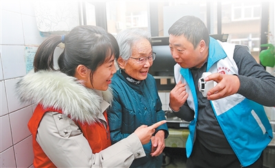 西安碑林区黄雁社区工作人员为独居老人讲解烟感器功能。 黄雁社区供图