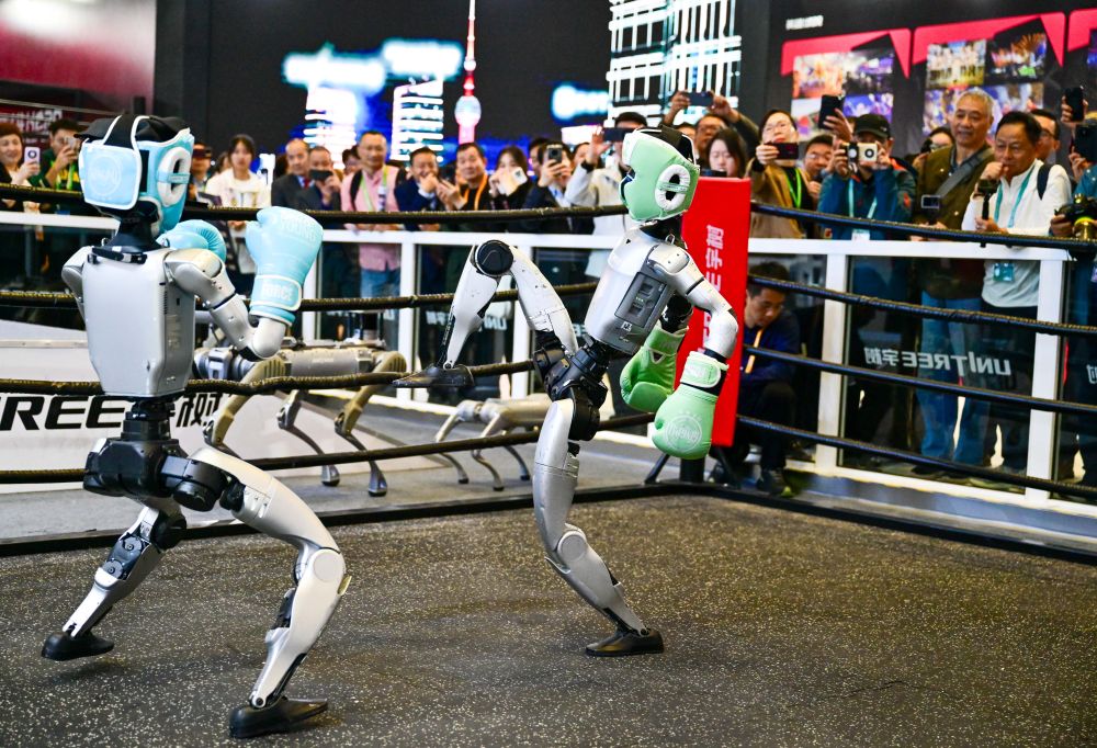 2025年11月6日,人形机器人在第八届进博会宇树科技展台进行格斗表演。当日,在技术装备展区宇树科技展台,两台G1人形机器人的格斗表演吸引了众多观众。它们戴着护具及拳套,施展直拳、勾拳、左右鞭腿,展示倒地自主起身等复杂动作,不时赢得观众喝彩。