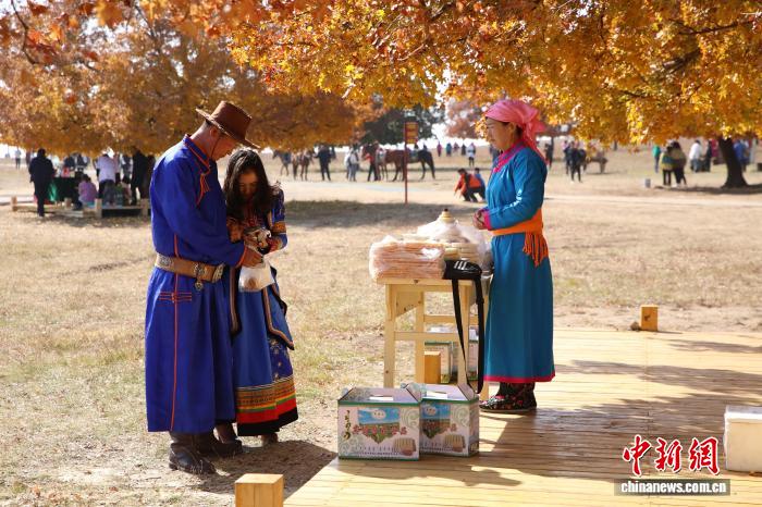 图为在五角枫生态旅游景区内,游客购买传统手工艺奶制品。 麦丽苏 摄