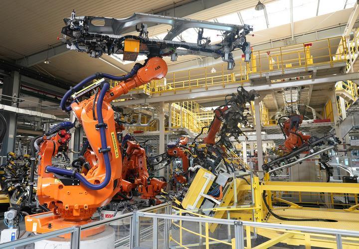 在位于浙江省临海市的吉利汽车制造基地,机械臂在焊装车间工作。新华社记者 翁忻旸 摄