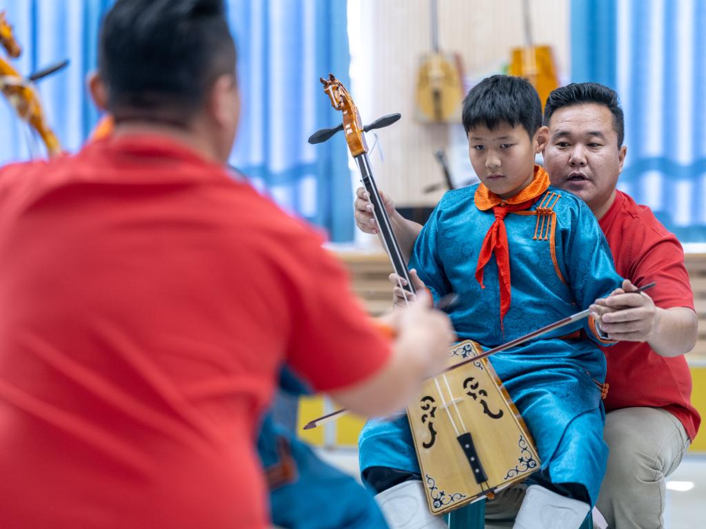 11月13日,在苏尼特右旗第五小学,乌云吉日嘎拉在指导“小小乌兰牧骑”的队员演奏马头琴。