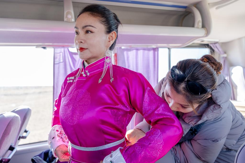 11月12日,演员们在大巴车上更换演出服装。