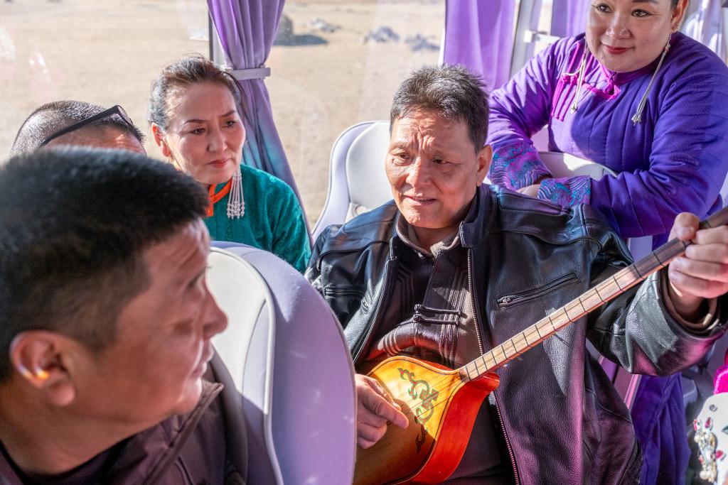 11月12日,已经退休的苏尼特右旗乌兰牧骑老队员塞西雅拉图在向其他演员演示乐器演奏技巧。