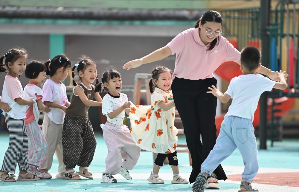 2025年9月10日,在山东省滕州市西岗镇中心幼儿园(柴里)分园,老师和小朋友一起玩“老鹰捉小鸡”趣味游戏。新华社发(李志军 摄)