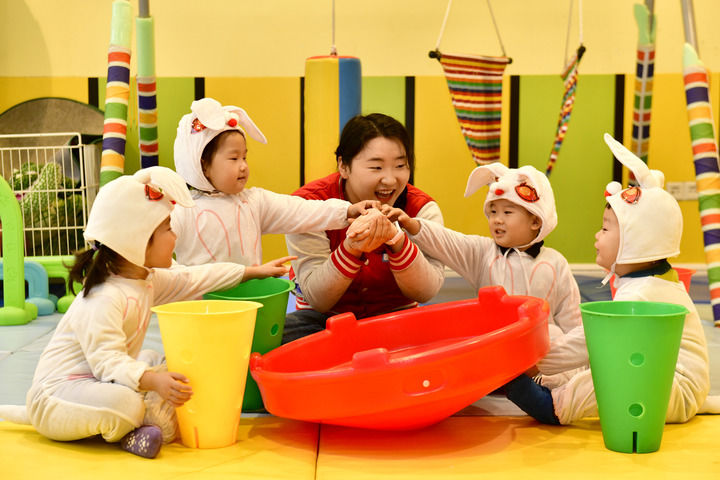 2025年2月20日,在山东省日照市东港区知子树托幼园,老师陪伴孩子做游戏。新华社记者 郭绪雷 摄