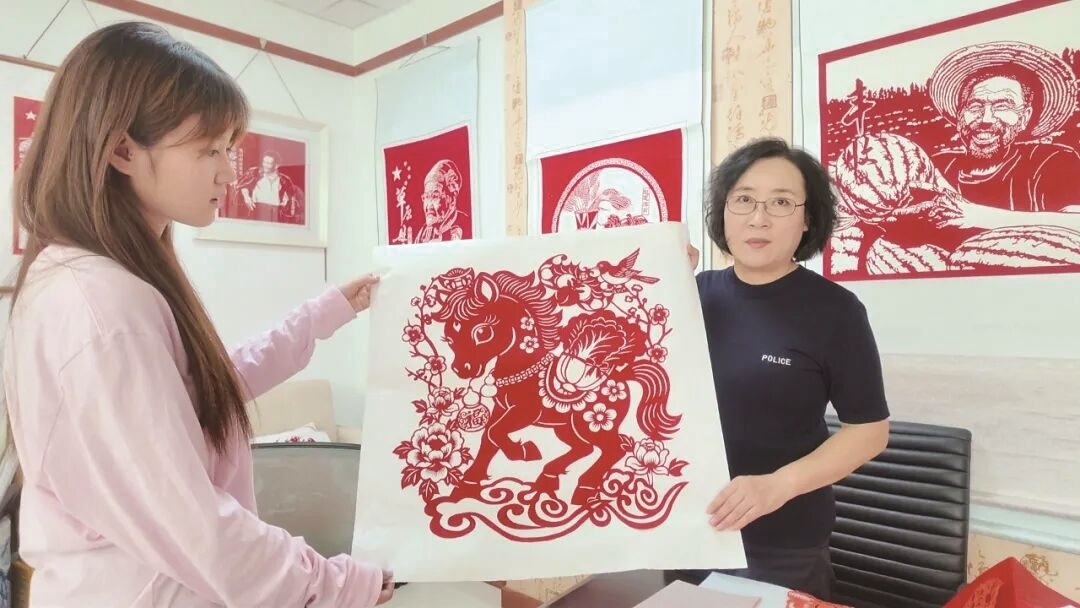 赵惠萍(右)展示她的剪纸作品