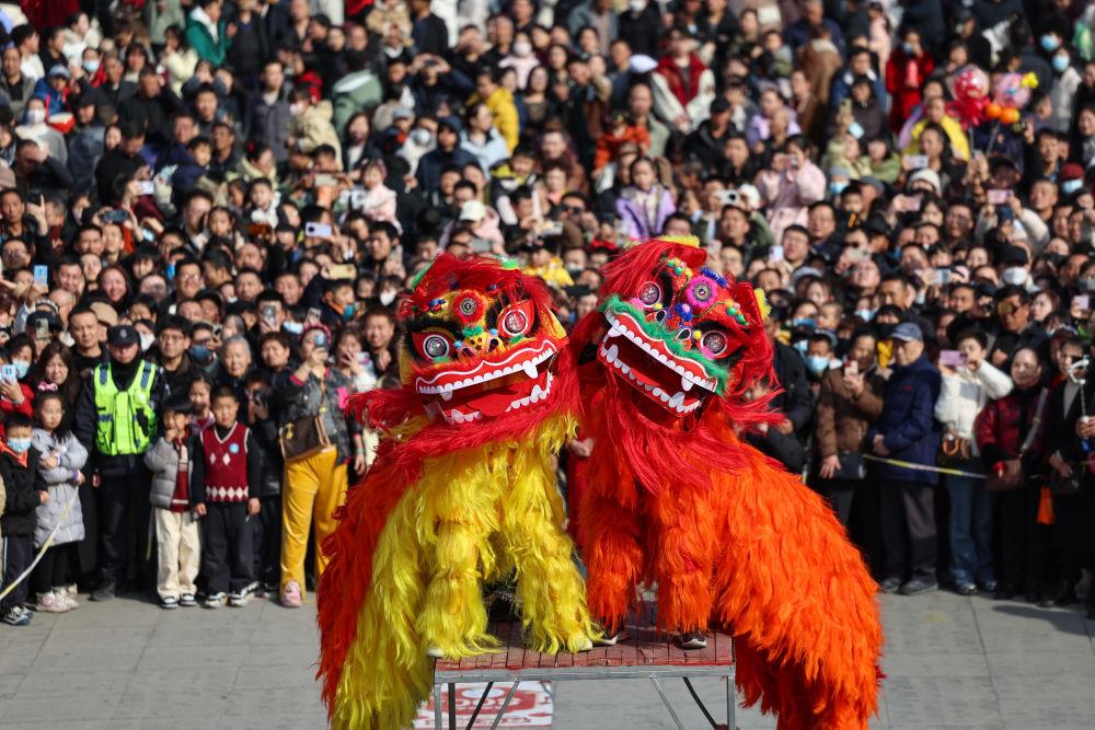△2026年2月18日,人们在甘肃兰州七里河区兰州老街观看舞狮表演。