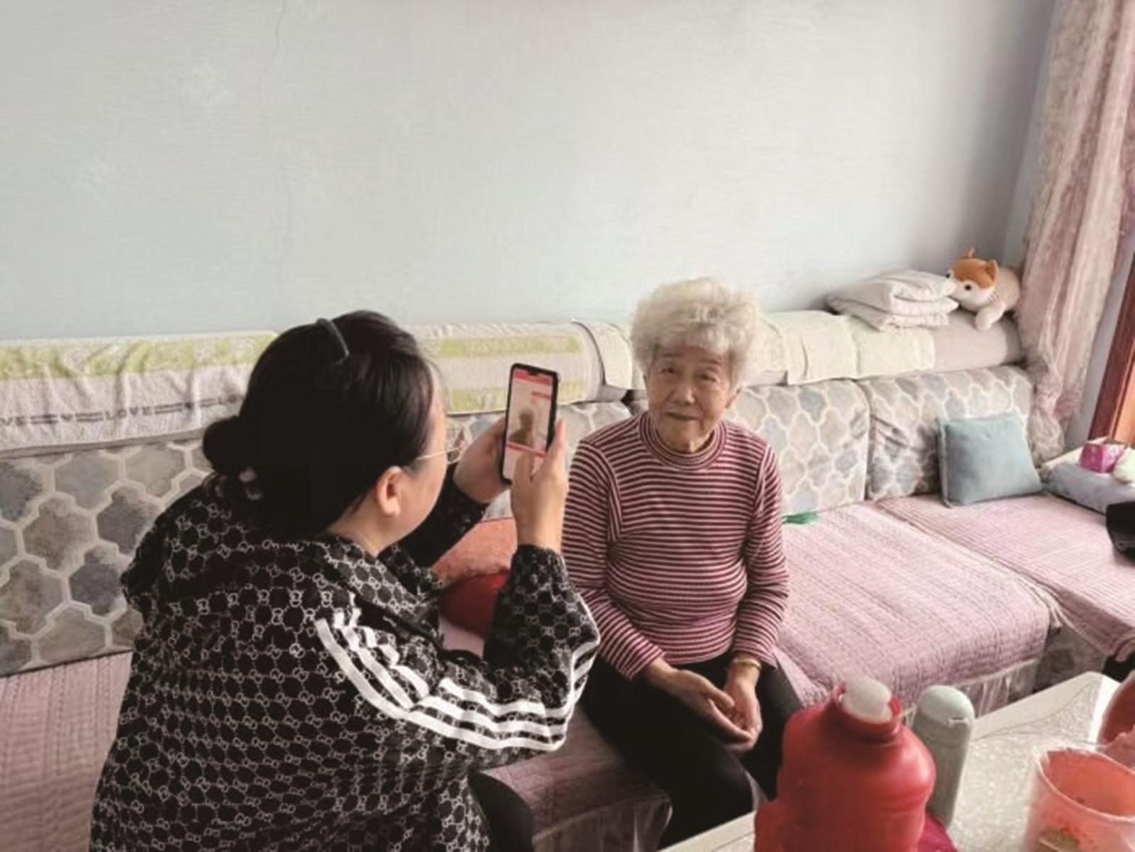 工作人员入户帮助老年人进行相关认证