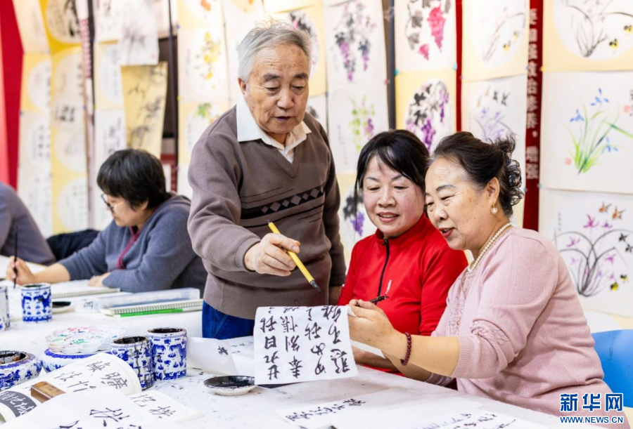 老年学员在呼和浩特市玉泉区老年大学书法课上交流书法技艺。新华网发(丁根厚 摄)