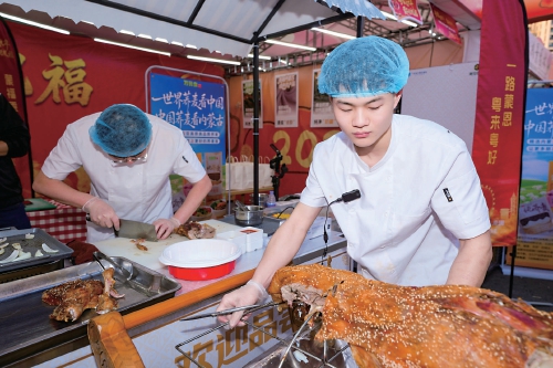 近日,内蒙古优质农畜产品走进大湾区活动现场,两位工作人员正专注处理内蒙古特色烤全羊。资料图