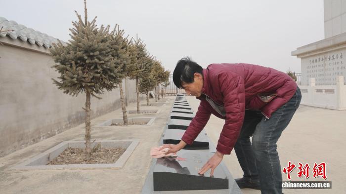 图为段宝祥擦拭烈士墓碑。李艳红 摄