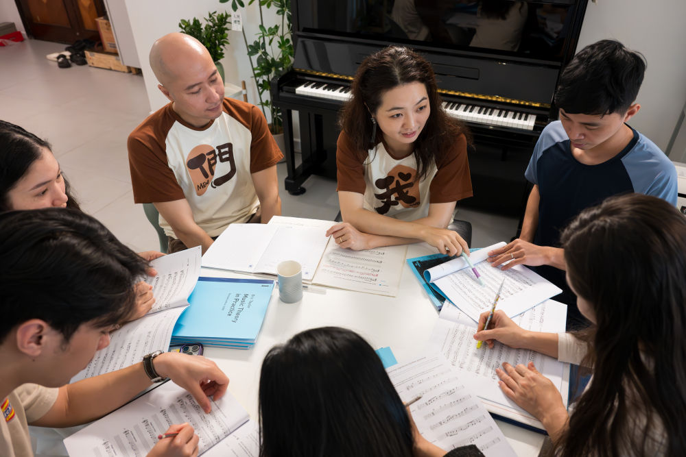 越南指挥家童光荣和中国作曲家莫双双是一对“跨国伉俪”,两人联手创立了“新活力”乐团,将越南传统竹乐和中国音乐元素融合编排,演绎出新的东方韵味。这是2025年3月28日,童光荣(中左)与莫双双(中右)在位于越南首都河内的家中为乐团成员授课。