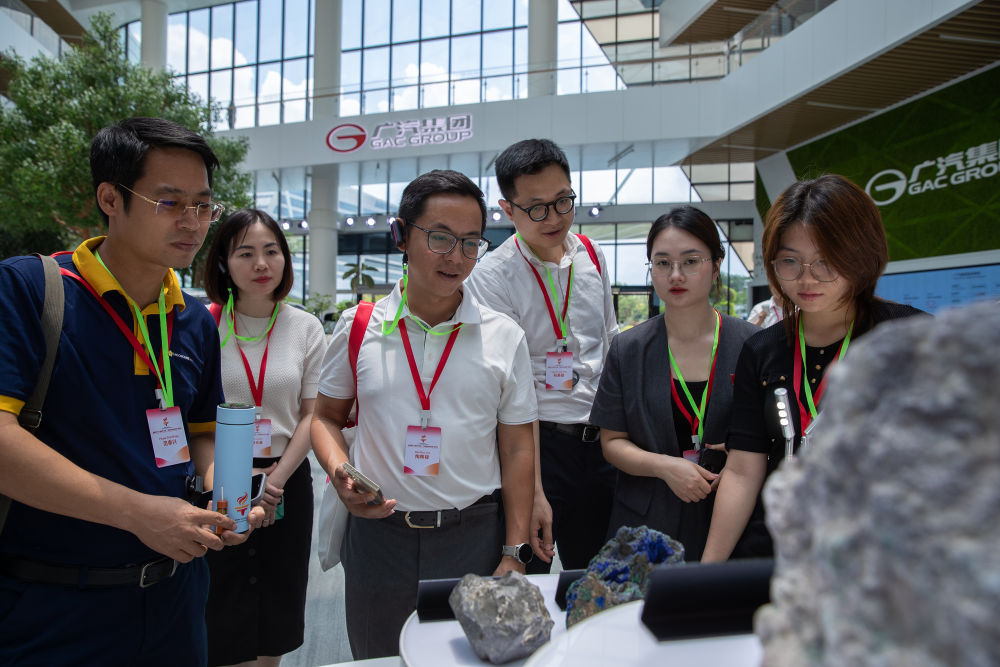 2025年5月21日,参加“红色研学之旅”的越南青年在广州广汽研究院电池材料展区参观。