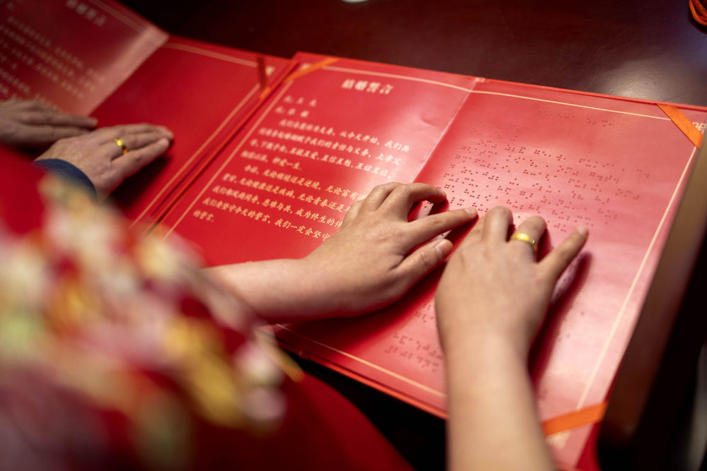 2024年3月12日,在北京市西城区婚姻登记服务中心,新人张女士和王先生提前熟悉无障碍版结婚誓言。这是我国首次为视障人士提供结婚登记无障碍格式文件。
