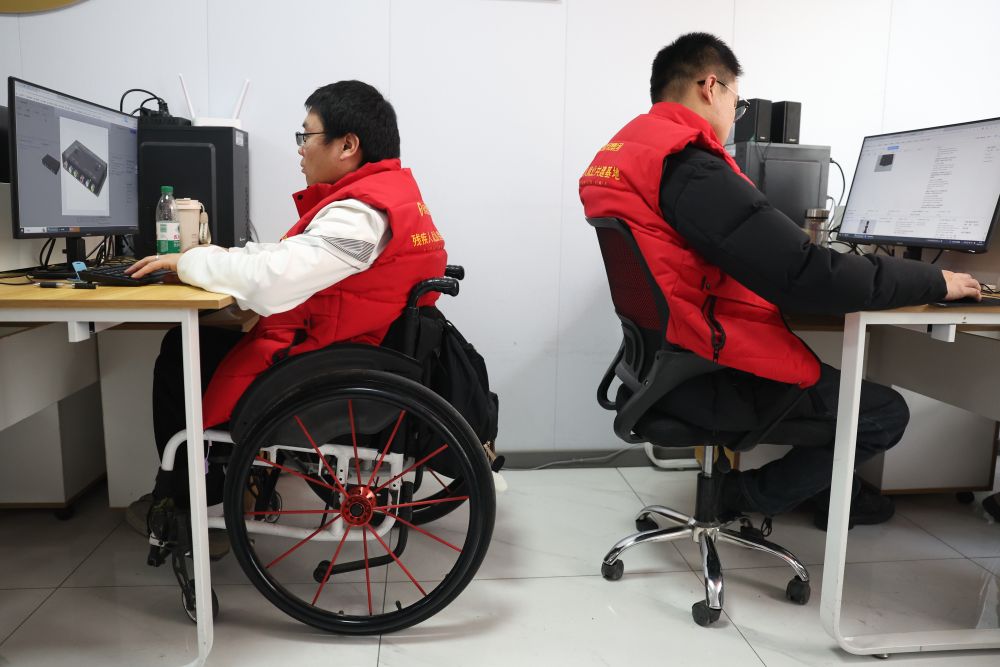2026年1月14日,在甘肃省兰州市心连心社会工作服务中心残疾人就业工坊,人工智能(AI)训练师李为明(左)进行数据标注工作。甘肃省残联与兰州市心连心社会工作服务中心联合高校共同举办面向残疾人的AI训练师数据标注培训班,首批来自甘肃各地的残疾人学员中,19人最终通过了人社部门承认的职业等级认定考试,获得了相应等级证书。不少学员已与企业签订就业协议持证上岗,开始从事数据标注工作。