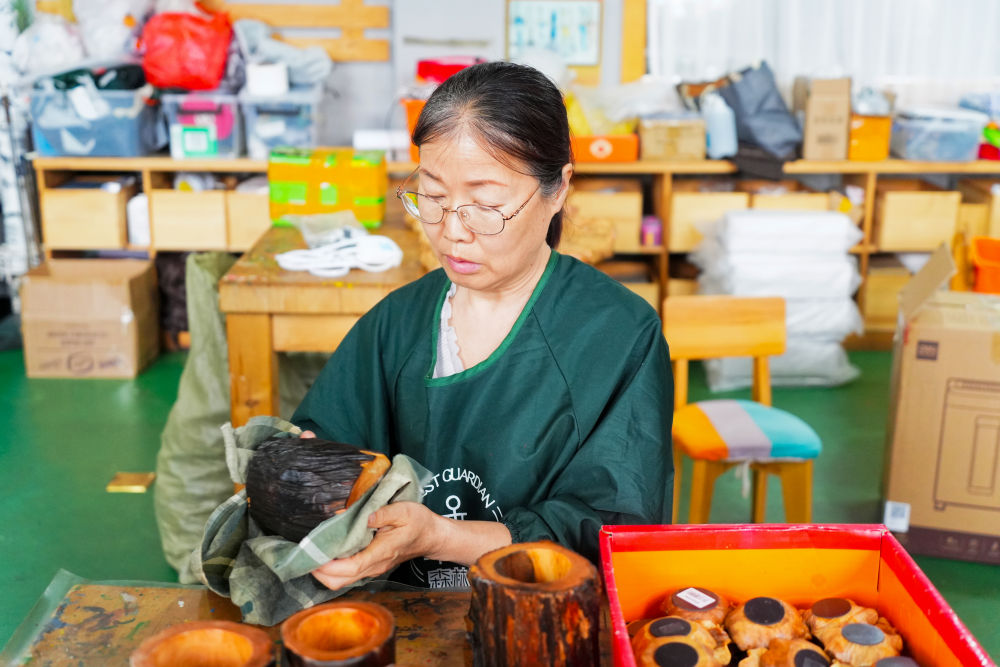 2026年5月12日,伊春永达工艺品有限公司员工正在擦拭制作好的松木工艺品。新华社记者 王祚 摄