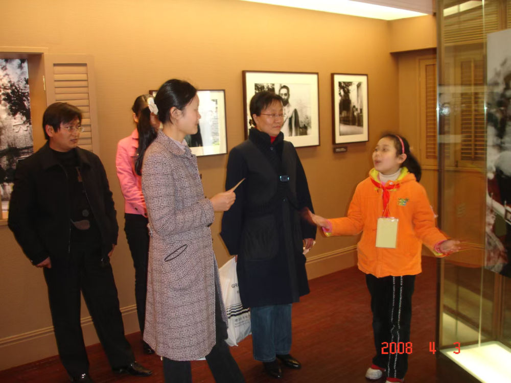 2008年,“红喇叭”小讲解员为参观者讲解。