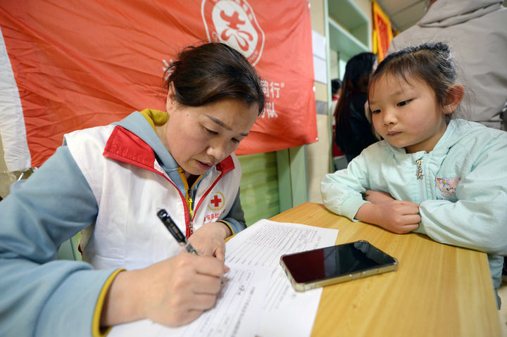 2025年4月24日,在贵州黔西南布依族苗族自治州兴义西南医院,红十字志愿者在登记信息。新华社记者 刘勇贞 摄