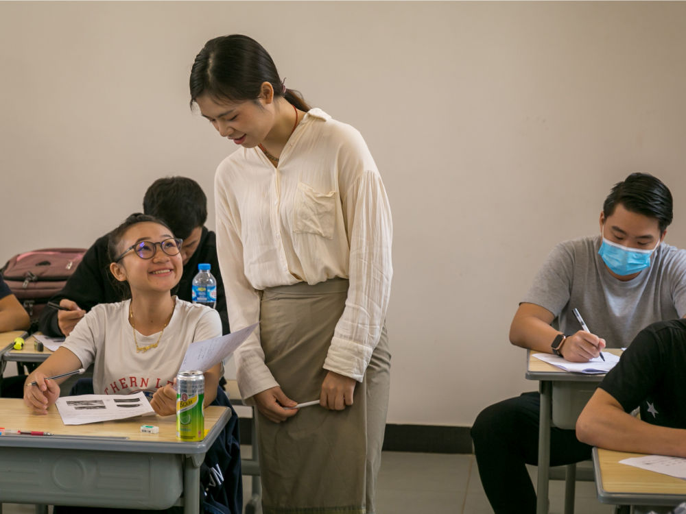 2020年7月15日,在老挝首都万象的老挝国立大学孔子学院,一名中老铁路老挝籍学员与老师交流。这些学员经过中文强化学习、铁路专业理论学习,来华现场实作培训和专业岗位技能培训后,通过考核即可成为中老铁路员工,入职火车司机、调度员、设备维修人员和基础设备维修人员等4类岗位。