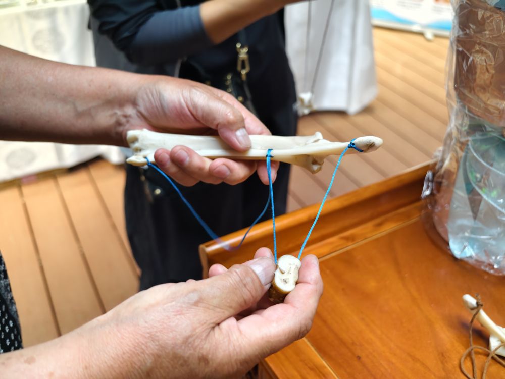 7月18日,二连浩特市蒙古包内,自治区级非物质文化遗产代表性传承人为游客展示特色游戏打开方式。