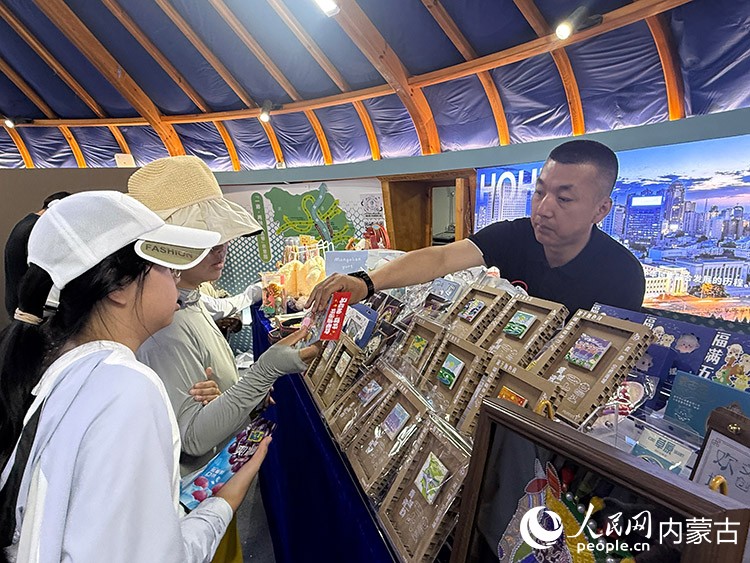 呼和浩特市的展示蒙古包里,工作人员正在给游客介绍文创产品。人民网记者 张力洋摄