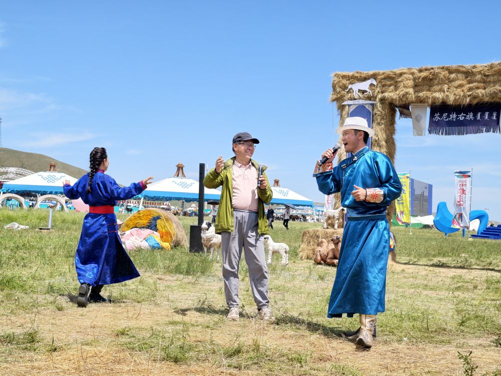 2026年7月19日,游客在会场内苏尼特右旗的蒙古包外与乌兰牧骑队员合唱歌曲。新华社记者 胡警丹 摄