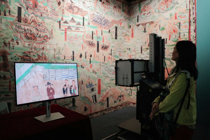 在敦煌研究院“典范”“高地”建设成果展上,游客参观莫高窟壁画高保真自动拍摄装置(2024年9月22日摄)。新华社记者 郎兵兵 摄