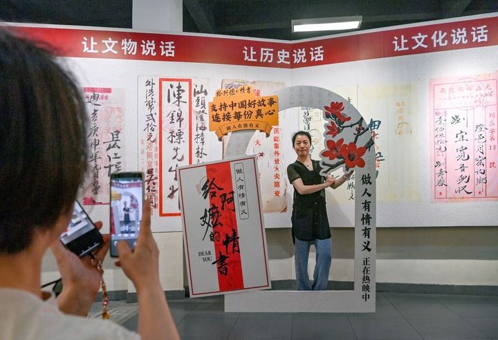 2026年5月18日,游客在广东省汕头市档案馆侨批分馆(侨批文物馆)内电影打卡点前拍照留念。新华社发(林鹏摄)