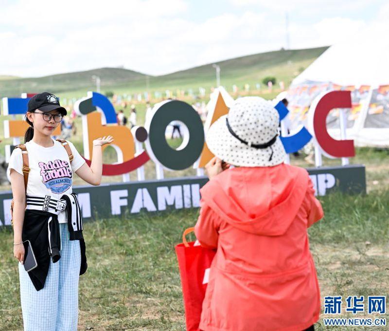 7月18日,游客在内蒙古自治区第36届旅游那达慕现场拍照打卡。新华社记者李志鹏摄
