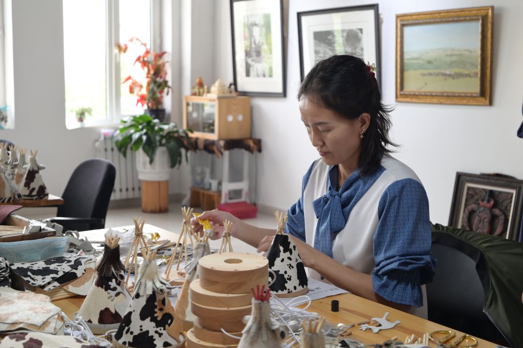 阿拉坦格日乐文化创意工作室内,一名女性正在制作简易皮艺小夜灯。新华社发