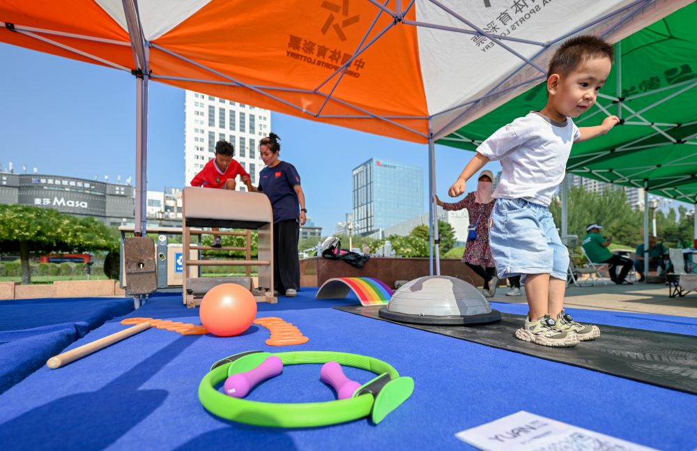 8月8日,2026年“全民健身日”内蒙古自治区主会场活动在包头市阿尔丁广场举行,一名小朋友体验健身器械。新华社记者 连振 摄