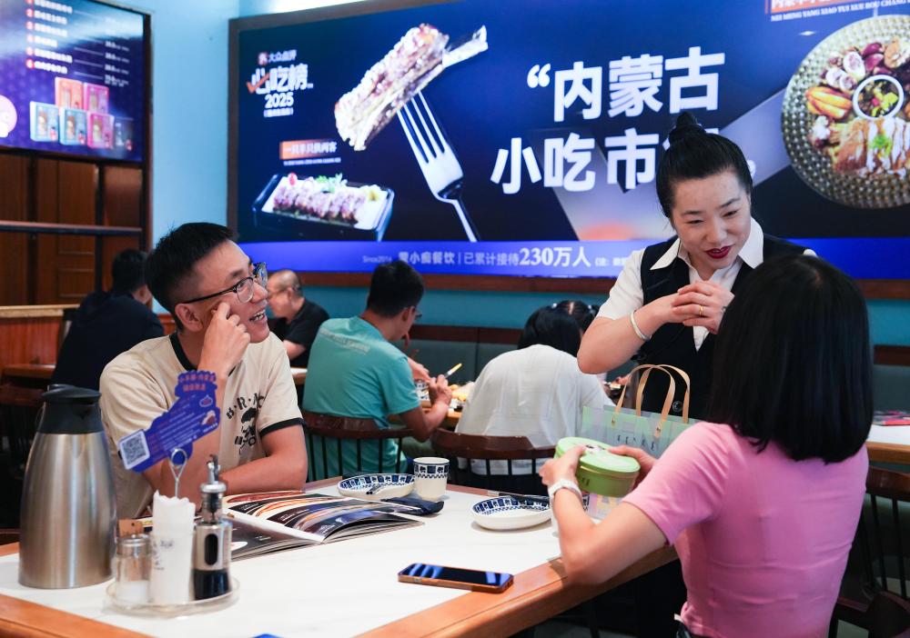 8月9日,餐饮店工作人员为点餐游客介绍本店特色美食。 (曹文进 摄)