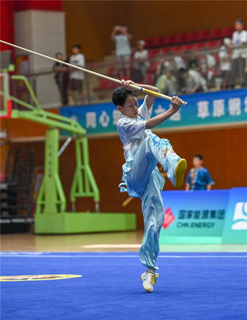 在武术套路项目男子乙组棍术比赛中,选手招式利落、英姿飒爽。