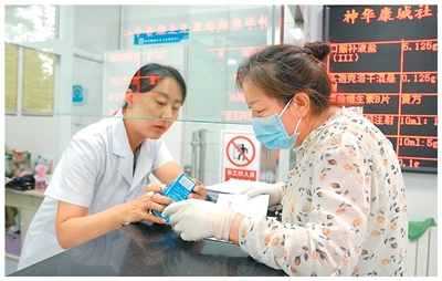 在鄂尔多斯市康巴什区神华康城社区卫生服务中心,医务人员详细了解居民的过敏药用药需求并发放药品。张 伟摄