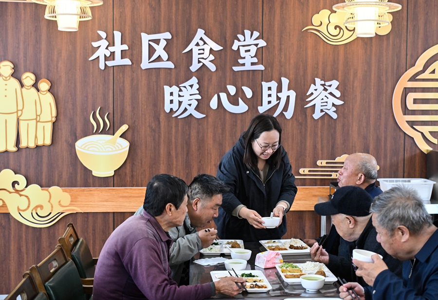 在江苏省扬州市江都区邵伯镇甘棠社区幸福邻里食堂,社区工作人员(左三)给老年居民端汤(2026年4月29日摄)。新华社记者 季春鹏 摄