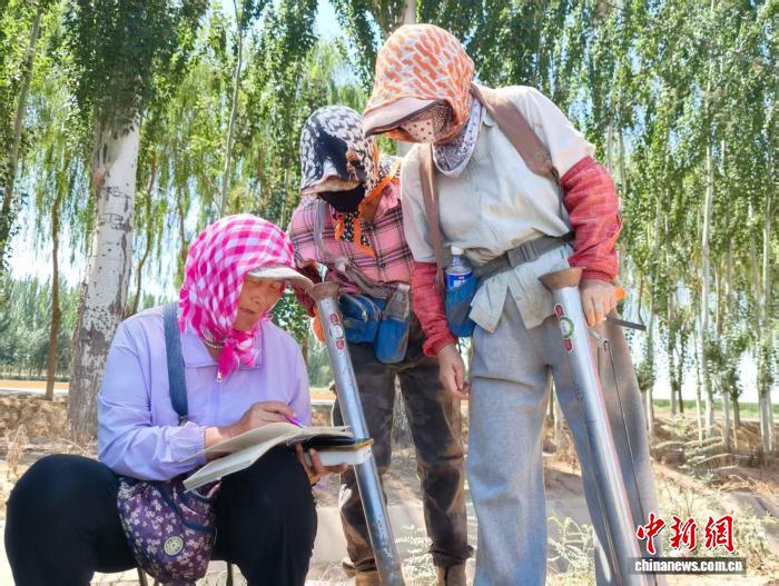 图为吕金梅给工人结算工钱。马娟 摄