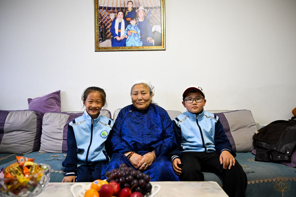 10月13日,乌云其其格(中)与孙女阿敏额尔敦(左)、外孙阿鲁斯合影。新华社记者 李志鹏 摄
